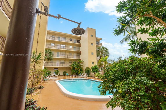 Outdoor swimming pool area with surrounding apartment buildings.