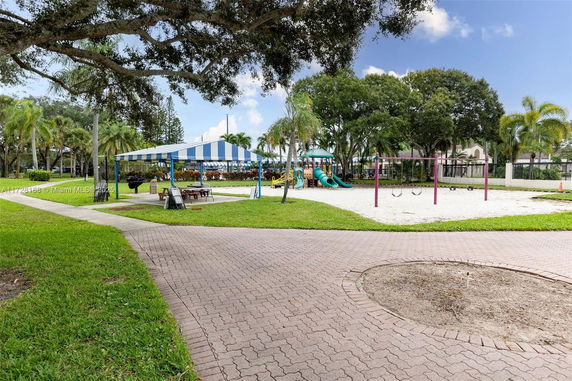 Outdoor playground with swings, slides, and a shaded picnic area.