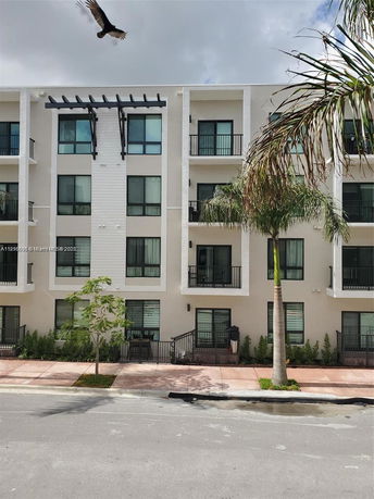 Front view of a multi-story residential building with balconies.