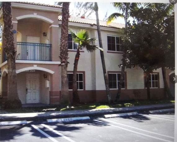 Front view of a two-story residential building with tiled roof and balcony.