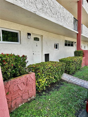 Front view of a building with textured walls and multiple windows.