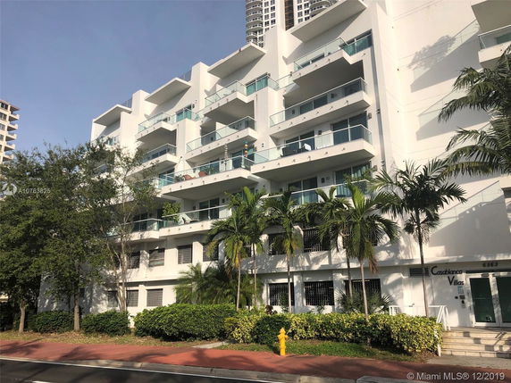 Front view of a multi-story apartment building with balconies.