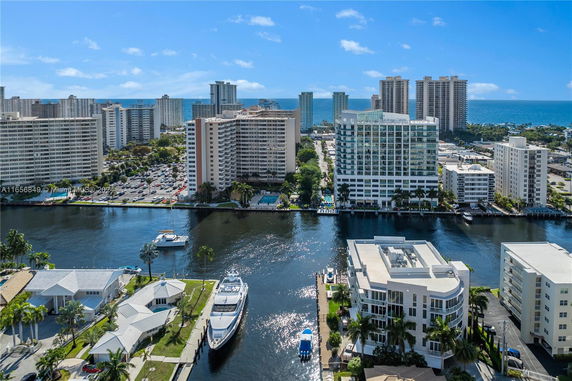 Aerial view of a waterfront area with several multi-story apartment buildings by the water's edge.