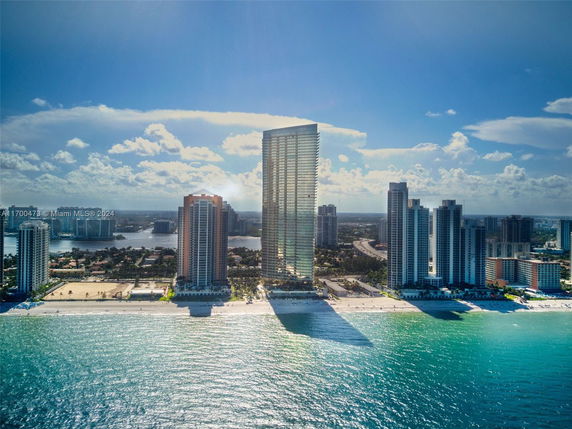 High-rise buildings on a coastal area with a view of the ocean and beach.