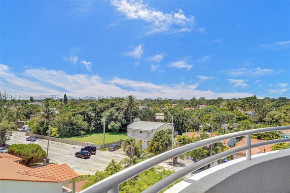 Panoramic view of a neighborhood with houses and trees under a clear blue sky.