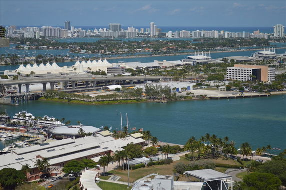 Aerial view of buildings and waterways with a backdrop of a city skyline.