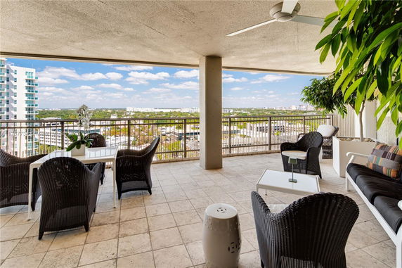 Outdoor balcony area with seating and panoramic view of cityscape.