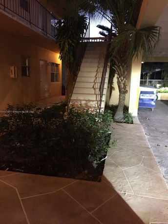 Outdoor view of a building with stairway and plants.