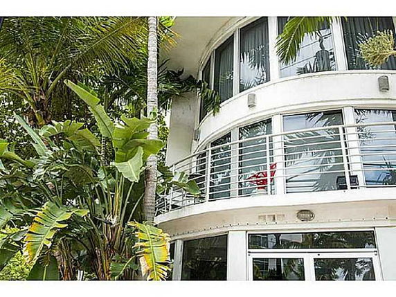 Front view of a contemporary two-story house with large windows and a balcony.
