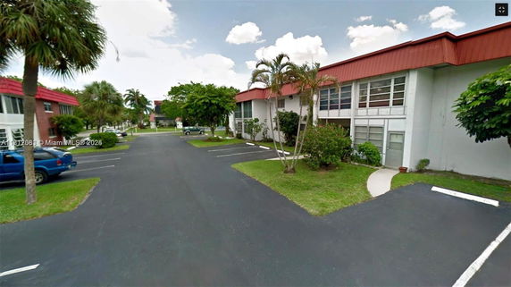 Outdoor parking area adjacent to a building with red-roof accents.