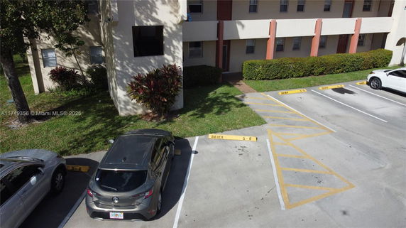 View of a parking area with parked cars in front of a building.