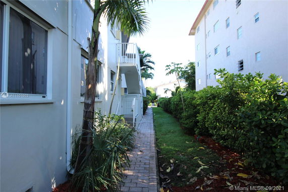 Side view of apartment buildings with pathway and greenery