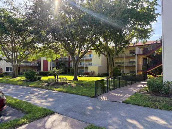 Front view of a multi-story residential building with balconies and exterior staircases.