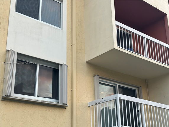Front view of a building with balconies and windows.