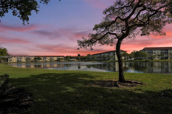 Distant view of buildings across a lake at sunset.