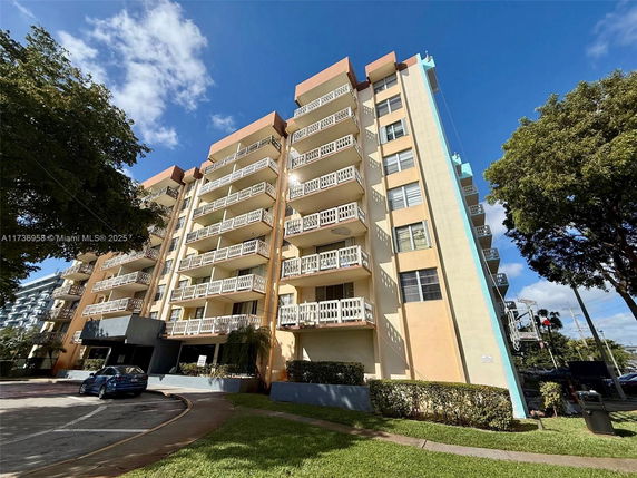 Front view of a multi-story apartment building with balconies.