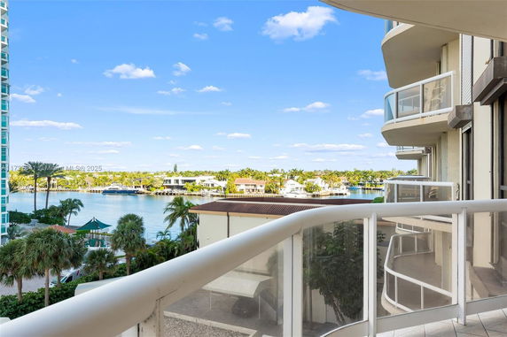 View from a building balcony overlooking water and distant residential area.