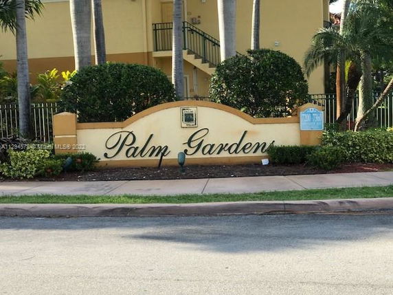 Front view of a building entrance with the name Palm Gardens on a sign.