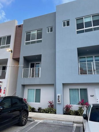 Front view of a modern multi-story building with balconies.