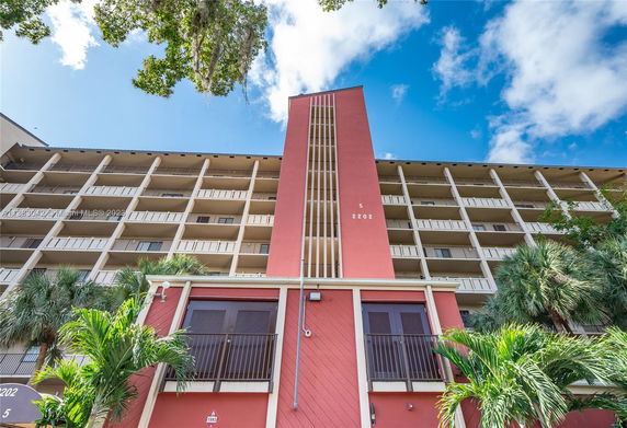 Front view of a multi-story building with a red facade and balconies.