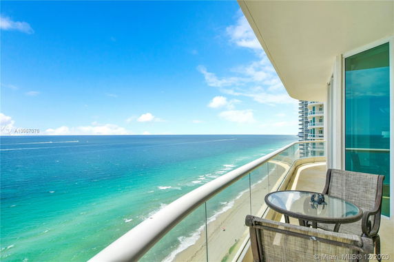 View from a balcony overlooking the ocean and beach.