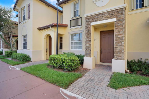 Front view of a two-story townhouse with a stone accent wall.