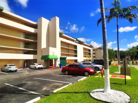 Multi-story building with adjacent parking area.