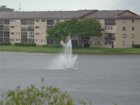 Residential building with a pond and water fountain in the foreground.