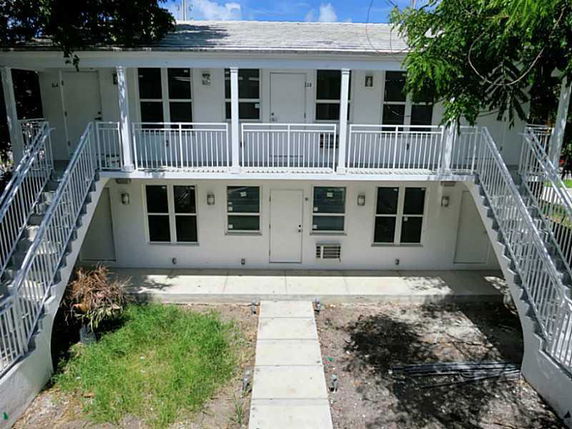 Front view of a two-story building with external staircases on both sides.