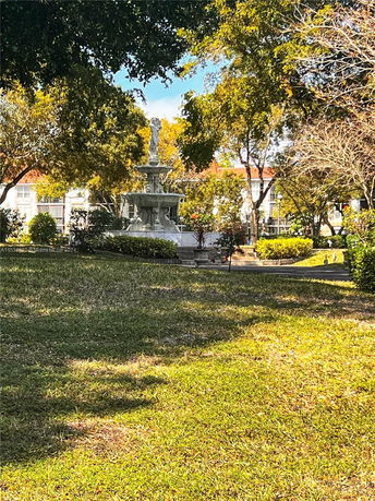 Outdoor area with a fountain and surrounding trees.