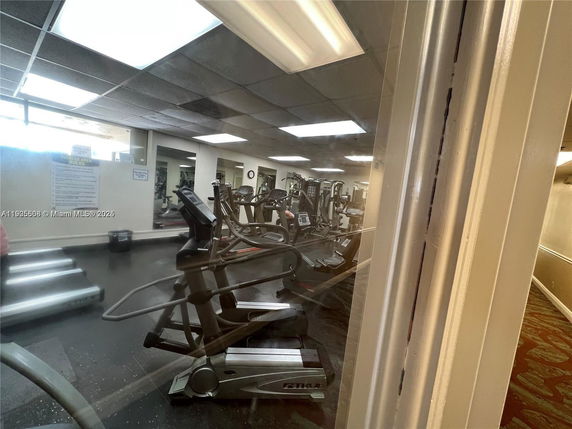 Indoor gym area with exercise equipment and mirrored walls.