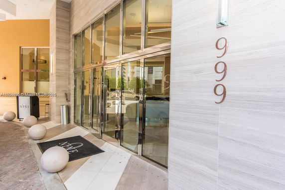 Front view of a building entrance with large glass doors and address '999' displayed.