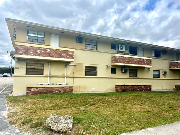 Front view of a two-story building with brick accents and air conditioning units.