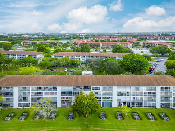 Aerial view of multiple residential buildings with parking and greenery.