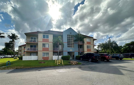 Front view of a three-story apartment building with balconies.