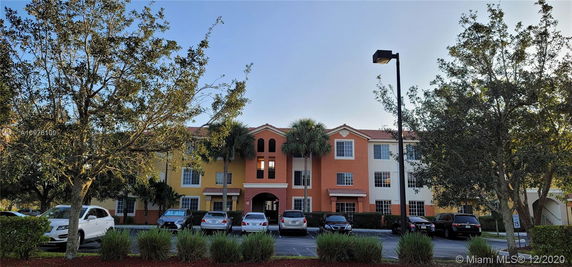 Front view of a three-story residential building with multiple windows.