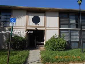 Front view of a two-story building entrance with large windows and a round feature above the door.