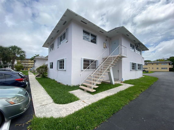Front view of a two-story residential building with external staircase.
