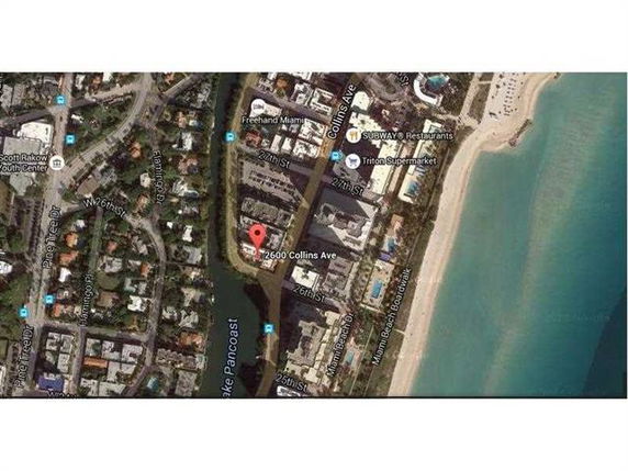 Aerial map view of buildings, roads, and a beach along a coastline.
