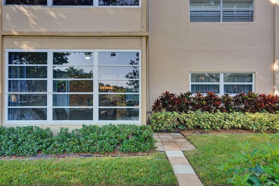 View of a building with large windows and landscaping in front.