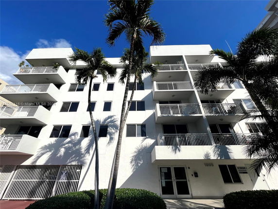 Front view of a multi-story apartment building with balconies.