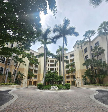 Front view of a multi-story resort building with palm trees.
