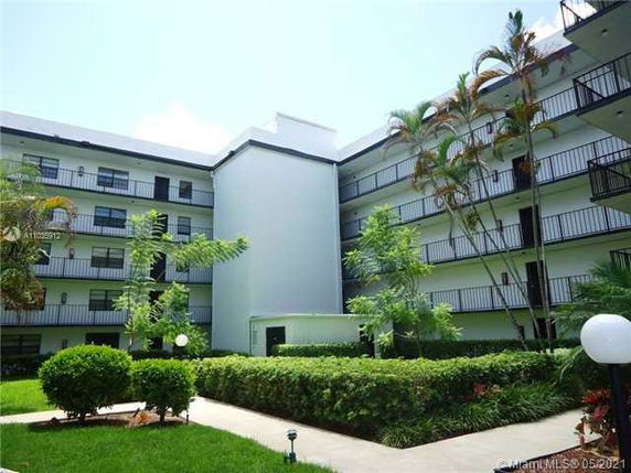 Front view of a multi-story building with balconies and a central courtyard.