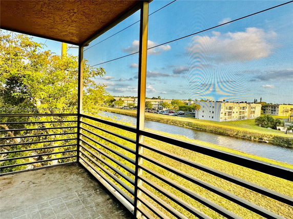 View from a balcony overlooking a canal and residential buildings.