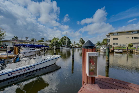 View from a dock overlooking a marina with boats and buildings.