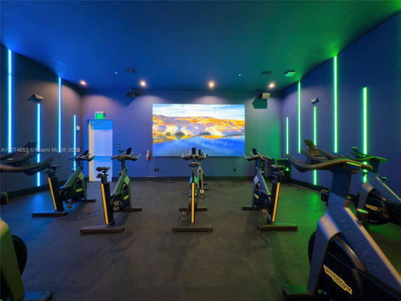 Indoor gym area with exercise bikes and vibrant lighting.