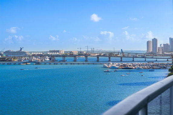Panoramic view of a large body of water with boats and a bridge in the distance.