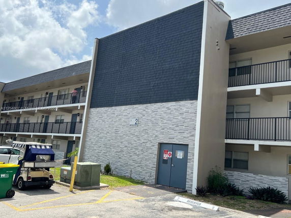 Front view of a multi-story building with a flat exterior and balconies.