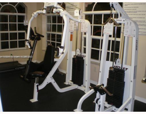 Indoor gym area with exercise machines and weights.