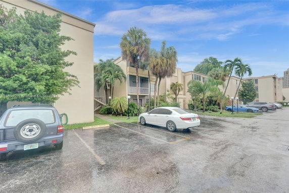 Outdoor parking area in front of a multi-story apartment building.